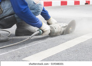 Worker grind hard asphalt road. Worker with high shear grinder cut and mill cement or asphalt or concrete to separate surface of road away. Danger job, to raise business.