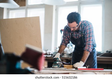 Arbeiter schleift das Holz der Winkelschleifmaschine