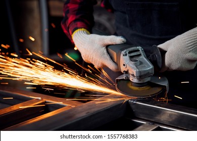 Worker hand with electric wheel grinding on steel structure in factory, light spark. - Powered by Shutterstock