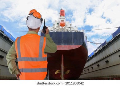 Worker Hand Holding Walkie Talkie In Shipyard The Bulk Carrier General Cargo Ship In Dry Dock Yard, Navigation Bridge Deck, Recondition Of Hull Repairing And Repainting, Working In Dry Dock Yard 