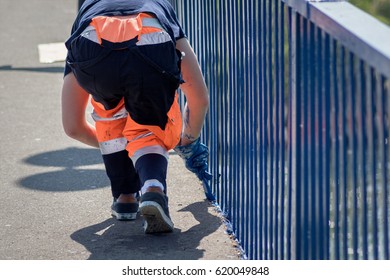 Worker Hand Painting Metal Fence With Brush