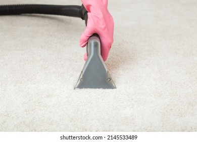 Worker Hand In Pink Rubber Protective Glove Using Spray Nozzle Of Professional Vacuum Cleaner And Washing Light Beige Carpet. Extraction Method. Commercial Cleaning Service. Closeup. Front View.