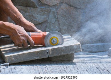 Worker hand using Grinder Machine to Cutting Concrete Block Floor for paving pavement job  