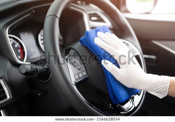 A worker\
hand wear glove cleaning car console steering wheel with microfiber\
cloth,  car wash detailing concept.\
