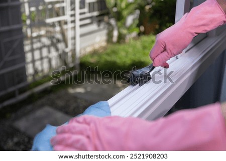 Worker hands cleaning sash window rails.