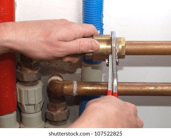 Worker hands fixing heating system with a special tool