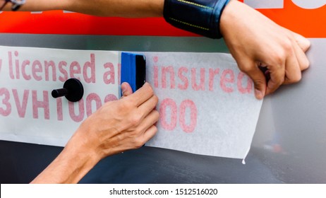 Worker Hands Installing Graphic Designs