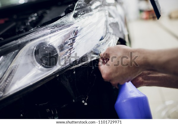 Worker hands\
installs car paint protection\
film