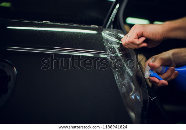 Worker
hands installs car paint protection film
wrap.