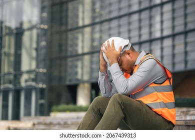 Worker hard working at construction site he tired and disconsolate. The civil engineer made a mistake, he was very stressed. Damage the structure of the building causing a breakdown.