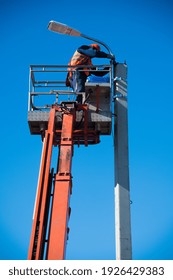 Worker With Helmet And Safety Protective Equipment Installs New Diode Lights. Worker In Lift Bucket Repair Light Pole. Modernization Of Street Lamps. 