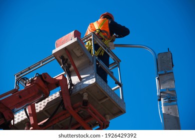 Worker With Helmet And Safety Protective Equipment Installs New Diode Lights. Worker In Lift Bucket Repair Light Pole. Modernization Of Street Lamps. 