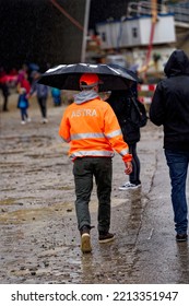 Worker With High Visible Jacket And Umbrella Of Federal Roads Office (FEDRO) At Open Day Of Highway Enclosure At City Of Zürich On A Rainy Day. Photo Taken October 1st, 2022, Zurich, Switzerland.