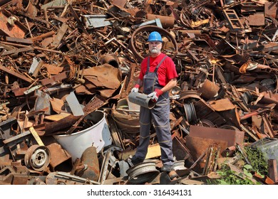 Worker Hold Tube At Heap Of Scrap Metal Ready For Recycling