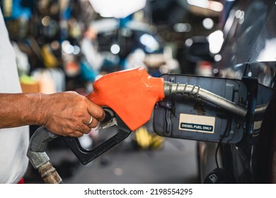 Worker Holding A Fuel Injector Is Refueling A Car In A Gas Station.