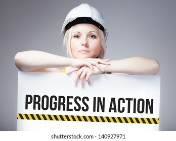 Worker holding progress in action sign placed on information board