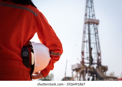 A worker is holding safety hardhat or helmet with blurred background of drilling rig derrick structure, selective focus at hardhat. Ready to working in oil field industrial concept photo. - Shutterstock ID 1926491867
