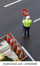 Worker Holding Stop Sign During Road Construction.