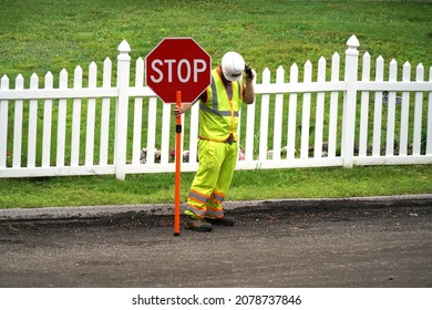 Worker Holding Stop Sign At The Side Of Street             