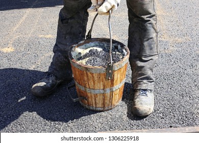 Worker Holding Tar Bucket