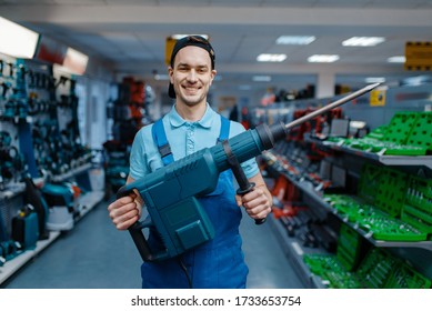 Worker Holds Big Electric Perforator In Tool Store