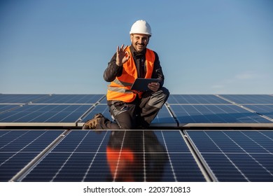 A worker holds tablet and showing okay gesture after testing tablet. - Shutterstock ID 2203710813