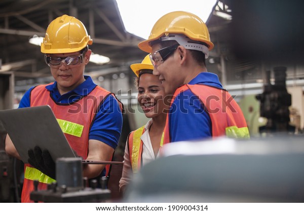 worker Industrial Engineers Talk with Factory\
Worker while Using Laptop. industrial worker is working. technician\
engineer and mentor checking process. machine metalworking industry\
concept copyspace