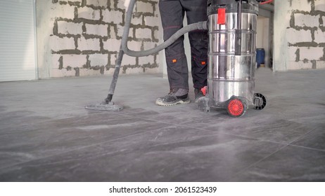 Worker With An Industrial Vacuum Cleaner. Professional Vacuum Cleaner. Professional Cleaning Of The Premises After Renovation.