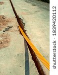 Worker inserts fiber optic cables buried in a micro trench