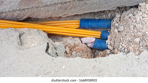 Worker Inserts Fiber Optic Cables Buried In A Micro Trench