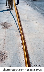 Worker Inserts Fiber Optic Cables Buried In A Micro Trench