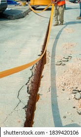 Worker Inserts Fiber Optic Cables Buried In A Micro Trench