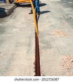 Worker Inserts Fiber Optic Cables Buried In A Micro Trench