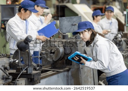 A worker inspecting a machine using a tablet PC
