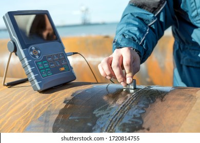 Worker is inspection to pipe welds with ultrasonic testing. The diagnostic machine displays these results in the form of a signal with an amplitude representing the intensity of the reflection. - Shutterstock ID 1720814755