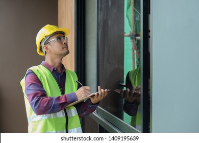 Worker, Inspector, Engineer Is Checking Building Structure Around Window With Checklist In Hand. Inspect And Checking Concept