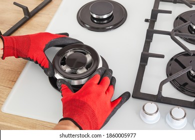 Worker Install Burner On Gas Hob In Kitchen Interior. Repairs Of Gas Control Panel.