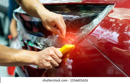 Worker Install Car Paint Protection Film With Spatula