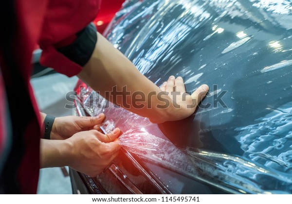 Worker install car\
paint protection film