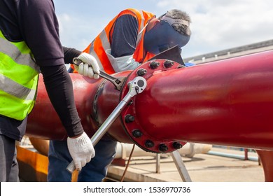 Worker Install Tightening Bolts & Nuts Of Piping Flange System. In The Industrial Plant.