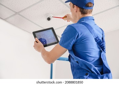 Worker Installing Alarm System Indoors