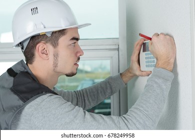 worker installing alarm system in office - Shutterstock ID 678249958