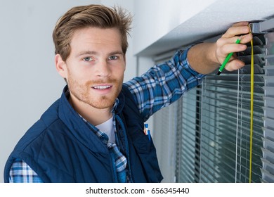worker installing a blind on a window - Shutterstock ID 656345440