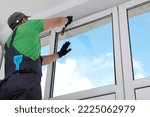 Worker installing double glazing window indoors, low angle view