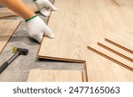 Worker Installing Interlocking laminate floor, home renovation.