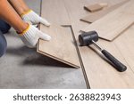 Worker Installing Interlocking laminate floor, home renovation.