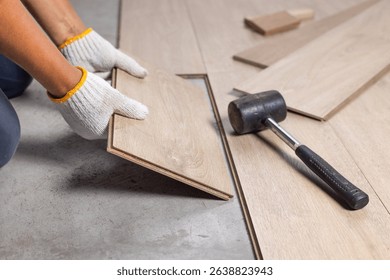 Worker Installing Interlocking laminate floor, home renovation.