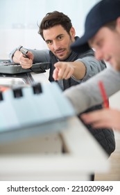 worker installing kitchen with apprentice