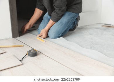 Worker installing new laminate flooring in room, closeup - Shutterstock ID 2262263789