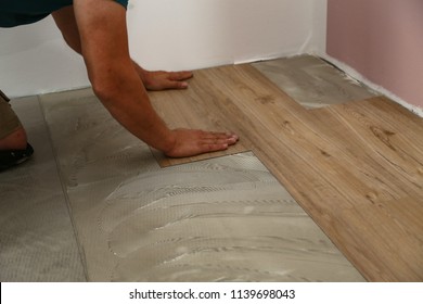 Worker Installing New Vinyl Tile Floor